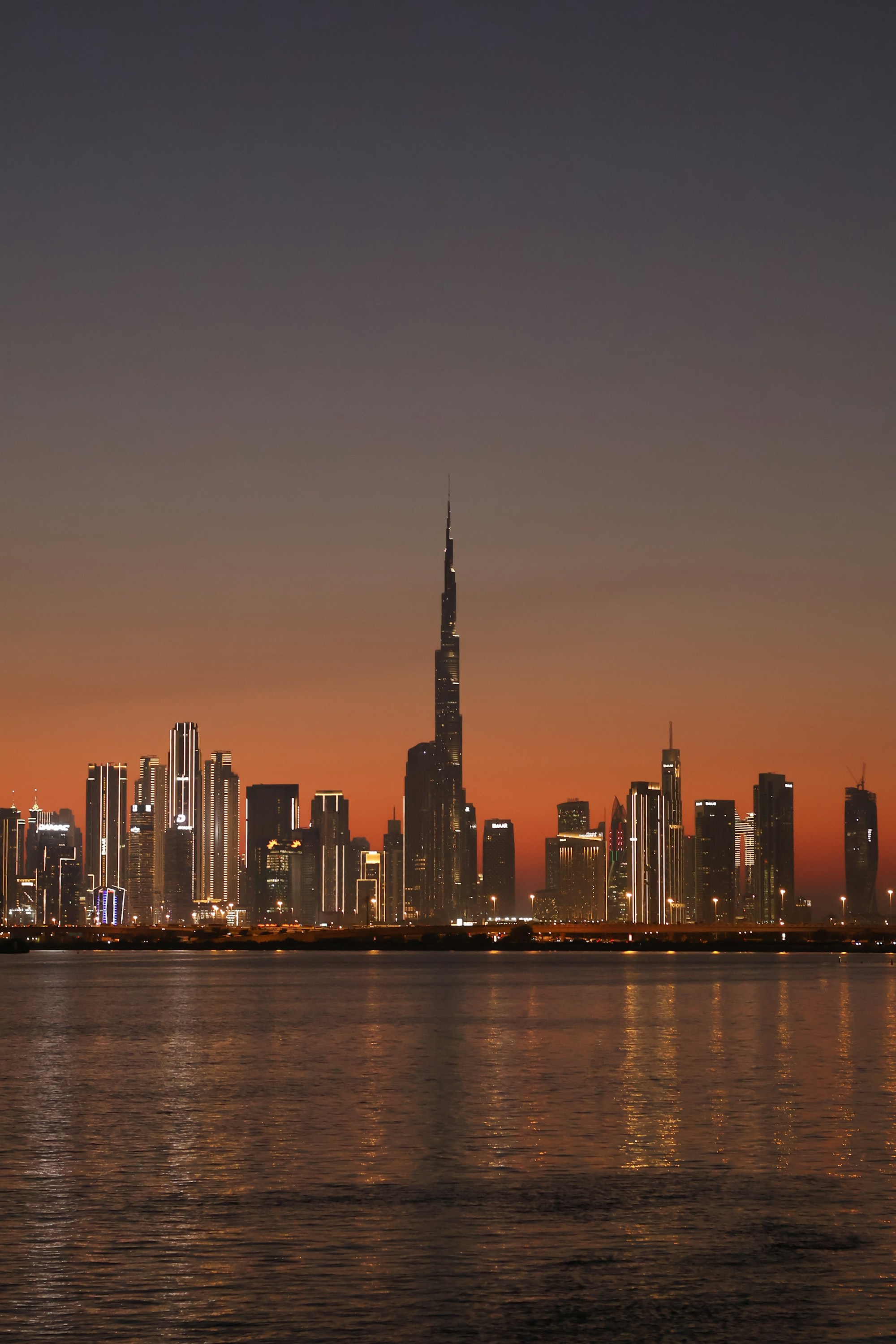 Dubai skyline and Burj Khalifa at dusk, photographed across the waterfront
